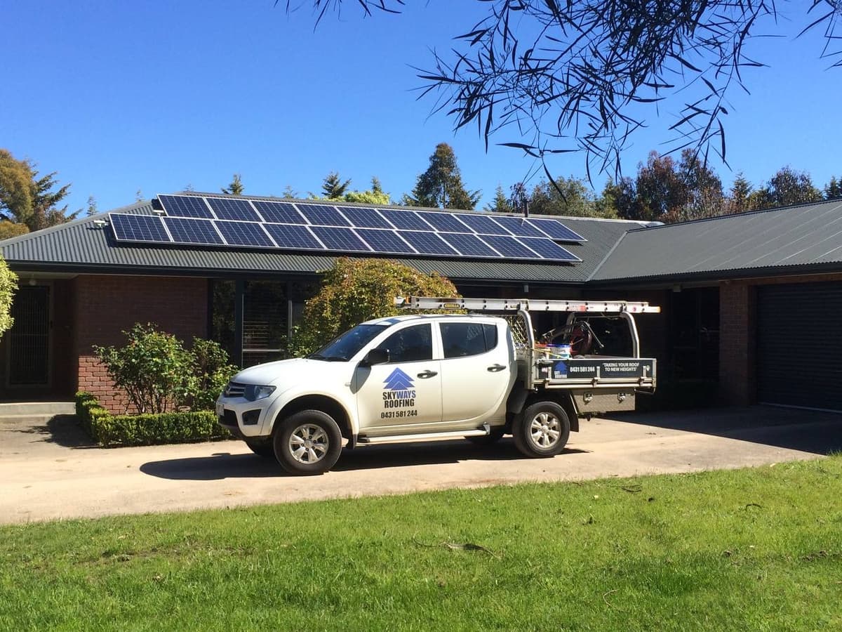 Skyways Roofing van on job site – metal roof with solar panels